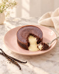 Lava cake cut open with flowing vanilla cream heart on a blush plate