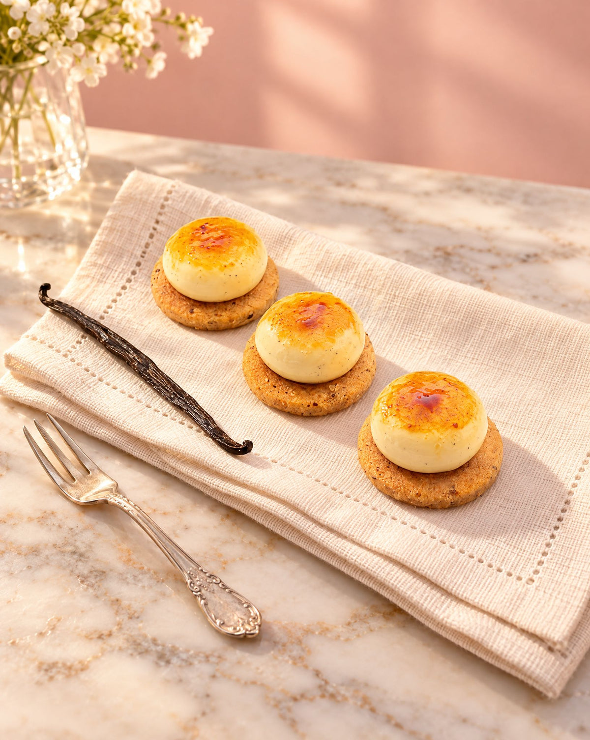 Creme brulee petit fours on a linen napkin with a vanilla pod