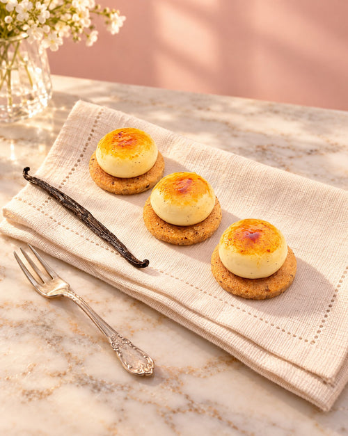 Creme brulee petit fours on a linen napkin with a vanilla pod