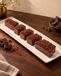 Finger chocolate explosion pastries on a long serving plate with dark chocolate shards
